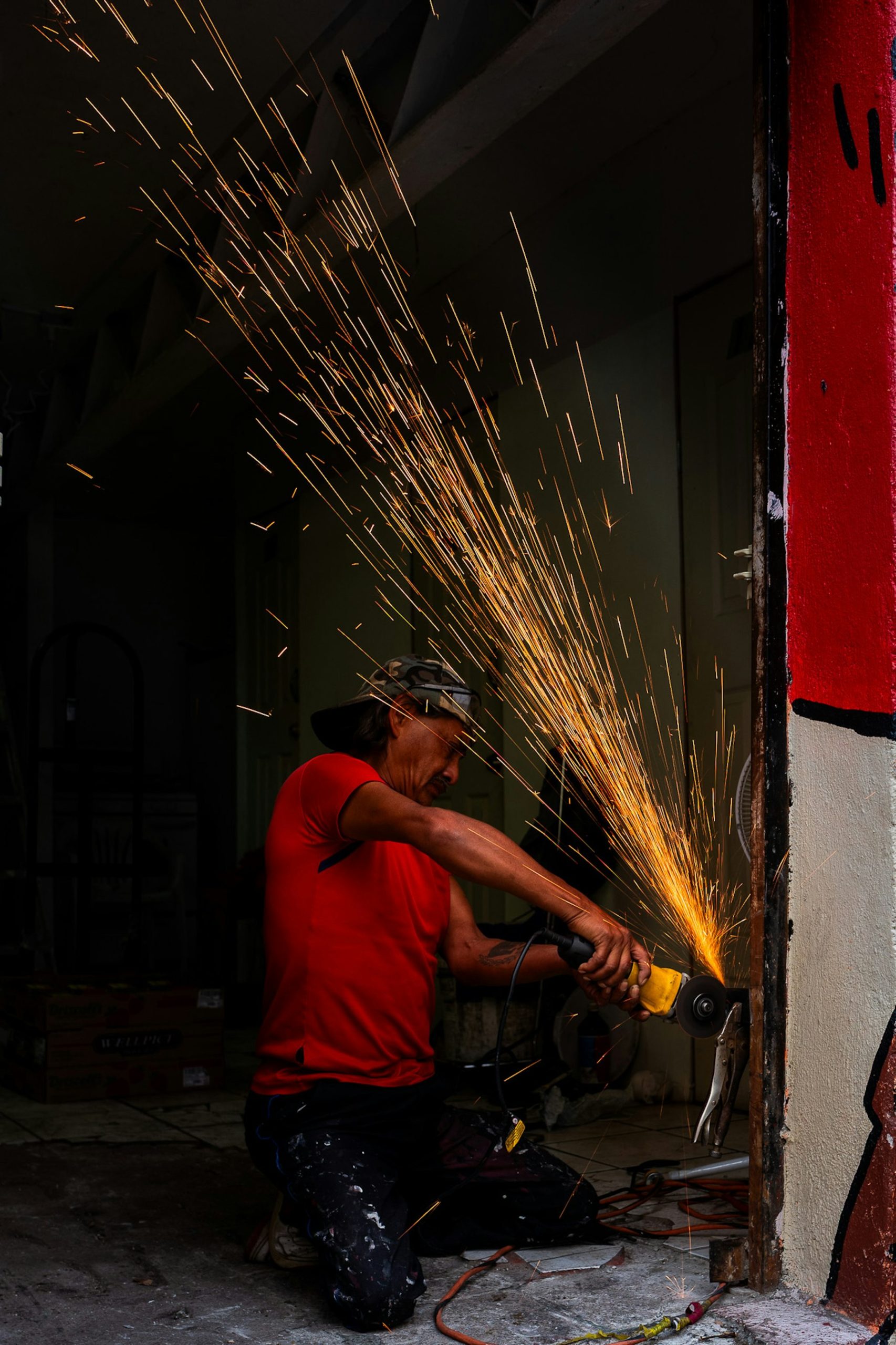 Worker using an angle grinder with sparks flying