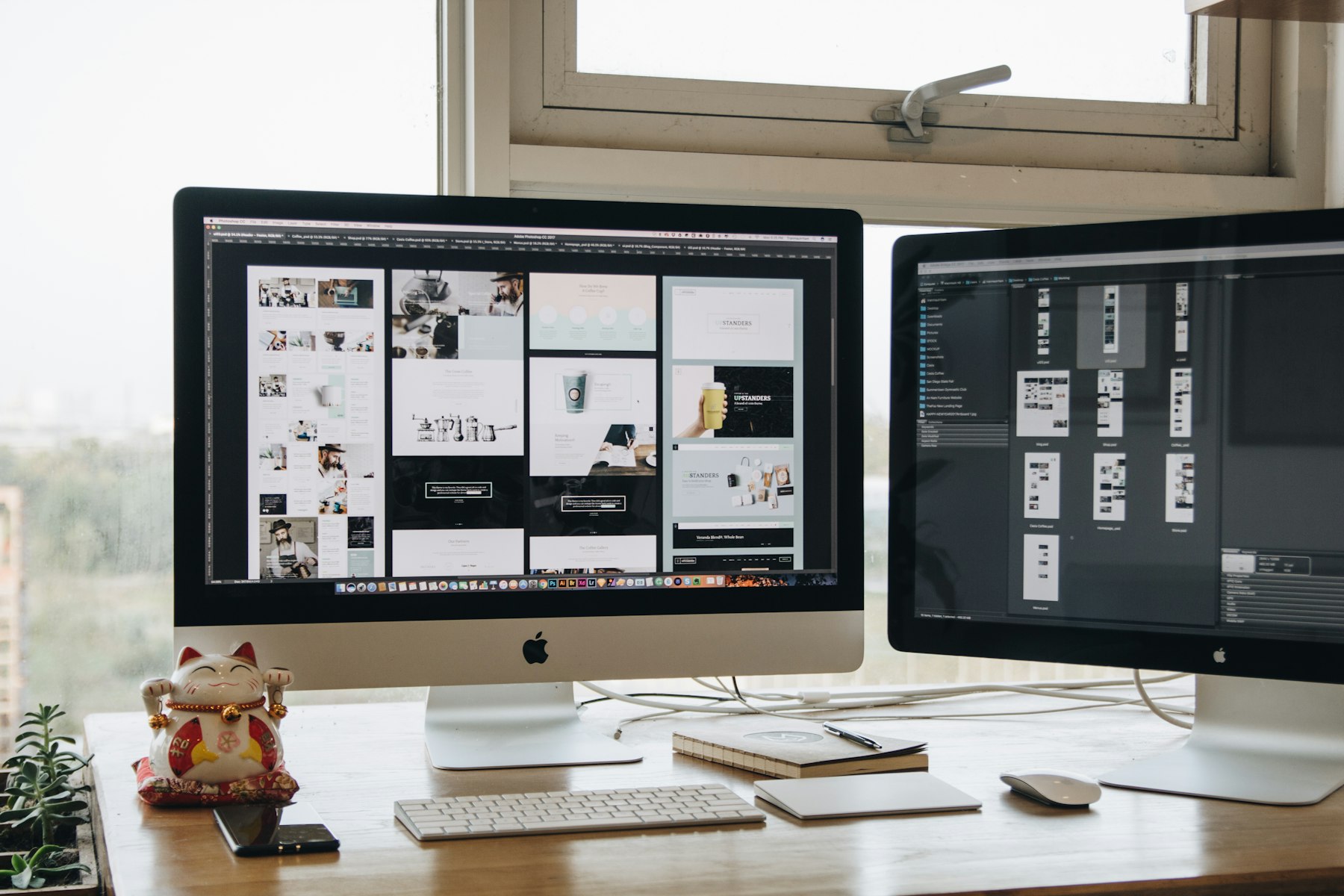 Designer working across two computer monitors